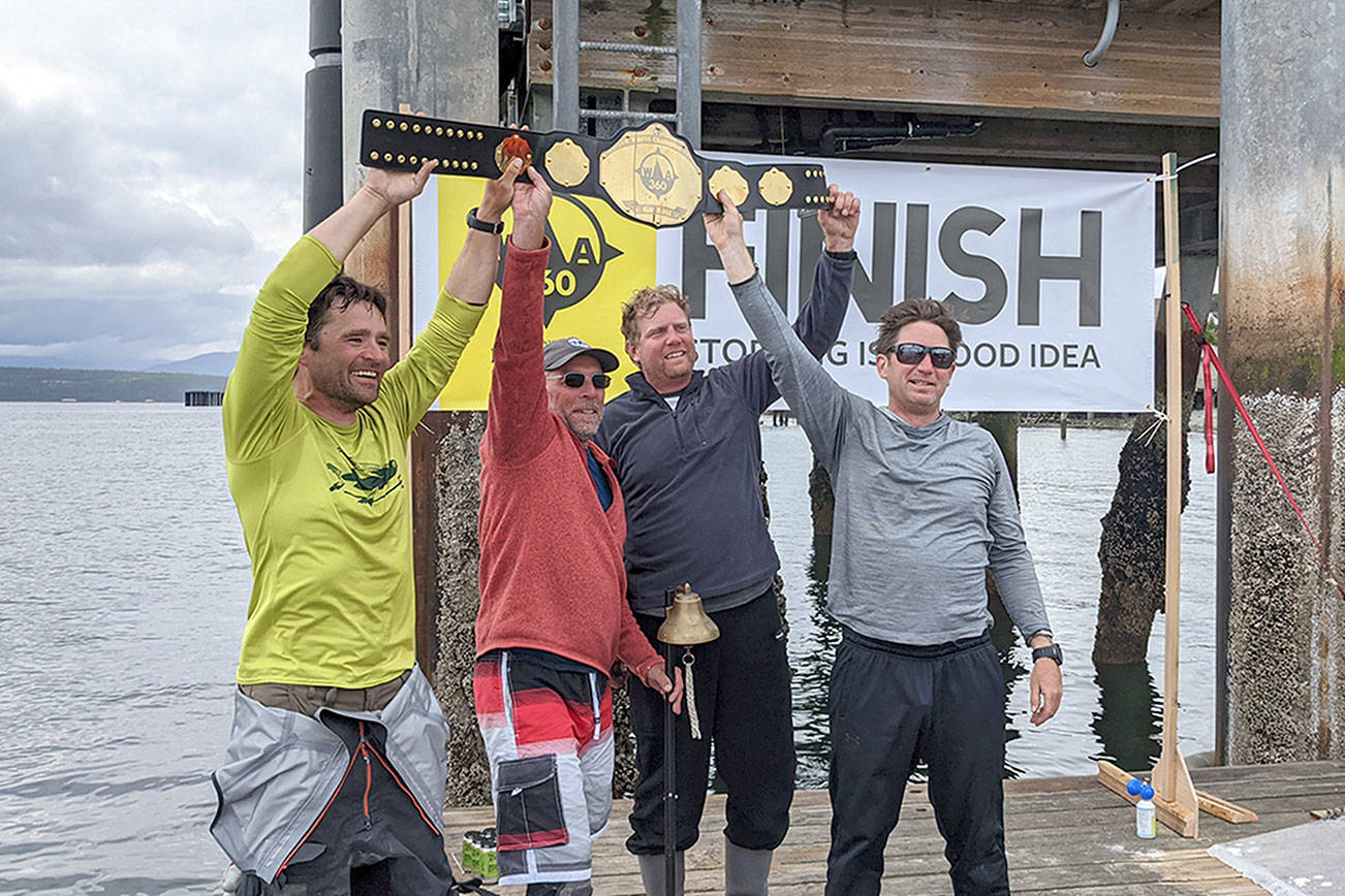Team High Seas Drifters Scott Wood, left, Mark Boston, Shad Lemke and Jefferson Franklin finished first and rang the bell while hoisting the first place belt for the WA360 on Thursday. The team finished the 360-mile race at 12:59 p.m., after leaving Port Townsend at 6 a.m. Monday. (Zach Jablonski/Peninsula Daily News)