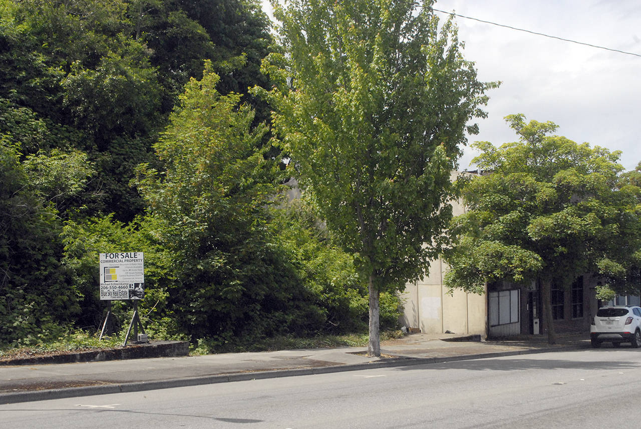 A pair of vacant building pads, once surrounded by fencing, stand next to an unoccupied building on Front Street near Lincoln Street at the entry to downtown Port Angeles. (Keith Thorpe/Peninsua Daily News)