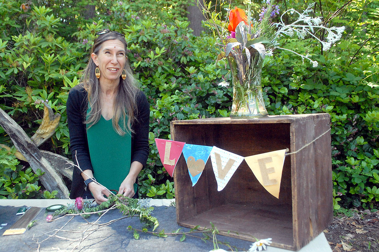 Christine Loewe, executive director of the Port Angeles Fine Arts Center, prepares a table display for Saturday’s Summertide Solstice Art Festival. (Keith Thorpe/Peninsula Daily News)