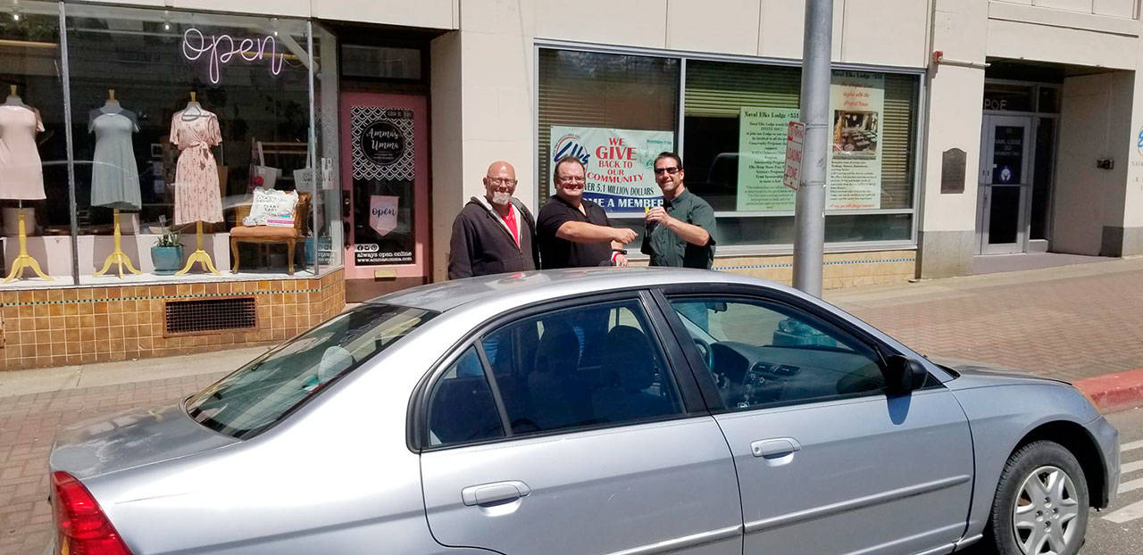 Sabaston Bushnell, left, looks on as Naval Elks Lodge Exalted Ruler Evan Boyd, far right. presents the keys to a Honda Civic to Ryan Bushnell. Bushnell, center, a service-related disabled veteran and a Port Angeles resident, has been commuting to his full-time job by bicycle for the past year. The car, which was donated to Naval Elks Lodge No. 353, was repaired by the automobile mechanics program at Peninsula College with parts donated by Simpson’s Towing and Salvage. Boyd also thanked Past Exalted Ruler Rob Gunn for taking care of the final touches on the car and coordinating the donation.