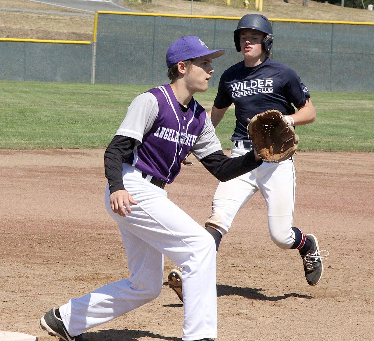 Wilder Junior baserunner Elijah Flodstrom cruises into third base safely as the Kitsap third baseman waits for the ball at Volunteer Field on Saturday. Kitsap won a pair of games against Wilder Jr. this weekend, but the Olympic Peninsula team won three out of five games played at Volunteer. (Dave Logan/For Peninsula Daily News)