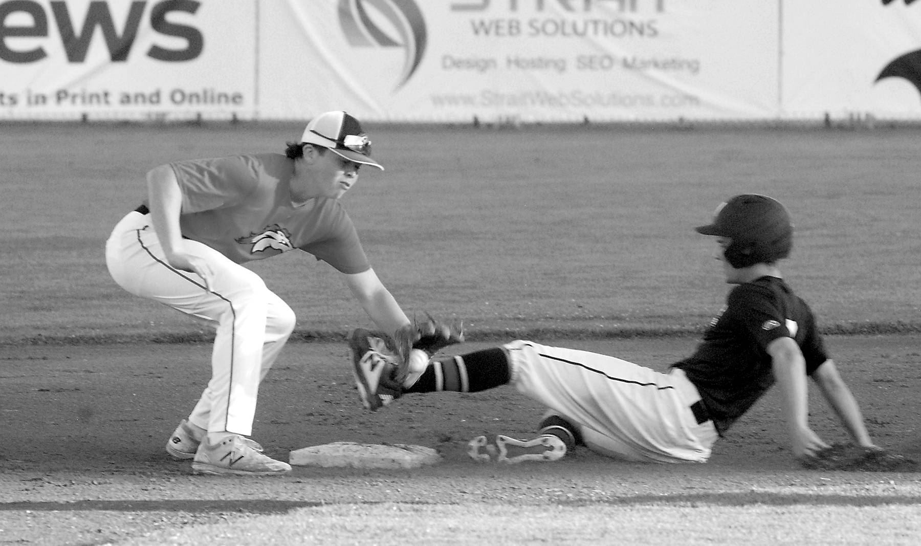 Photos by<strong> Keith Thorpe</strong>/Peninsula Daily News
Wilders Logan Olson, right, makes it to second, beating the throw to WBS Colts Red shortstop Grady Smith on Saturday in Port Angeles.