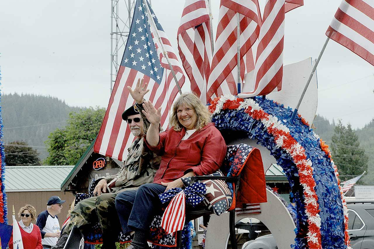 Sam McElravy, who served in the U.S. Army as Special Forces Green Beret from 1966-69, rides in a float with his wife Phyllis on Sunday during a Fourth of July parade in Forks. (Lonnie Archibald/For Peninsula Daily News)