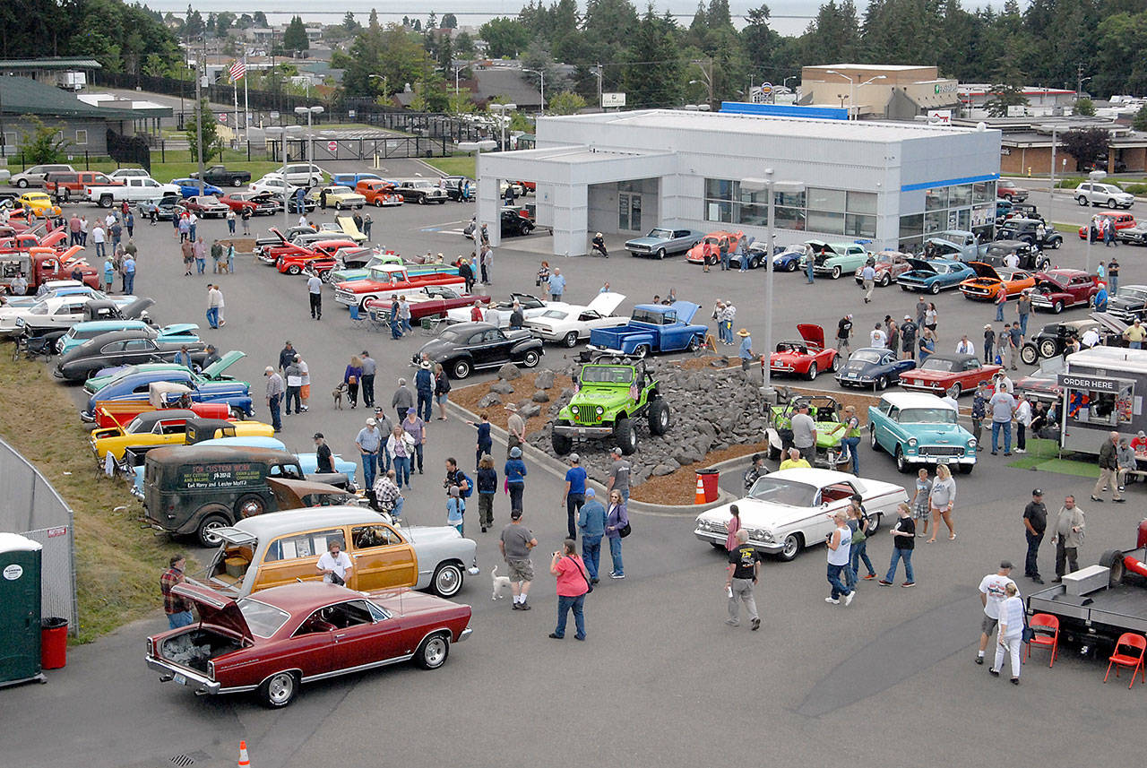 Auto enthusiasts walk around vintage cars and trucks at the 2019 Ruddell Cruise-in at Ruddell Auto Mall in Port Angeles. (Keith Thorpe/Peninsula Daily News)