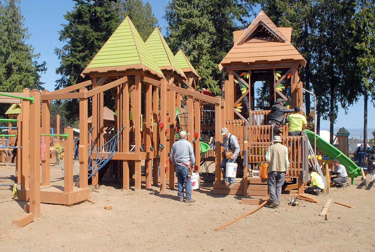 Volunteers put the finishing touches on a treehouse play structure on Saturday at the Generation II Dream Playground in Port Angeles. (Keith Thorpe/Peninsula Daily News)