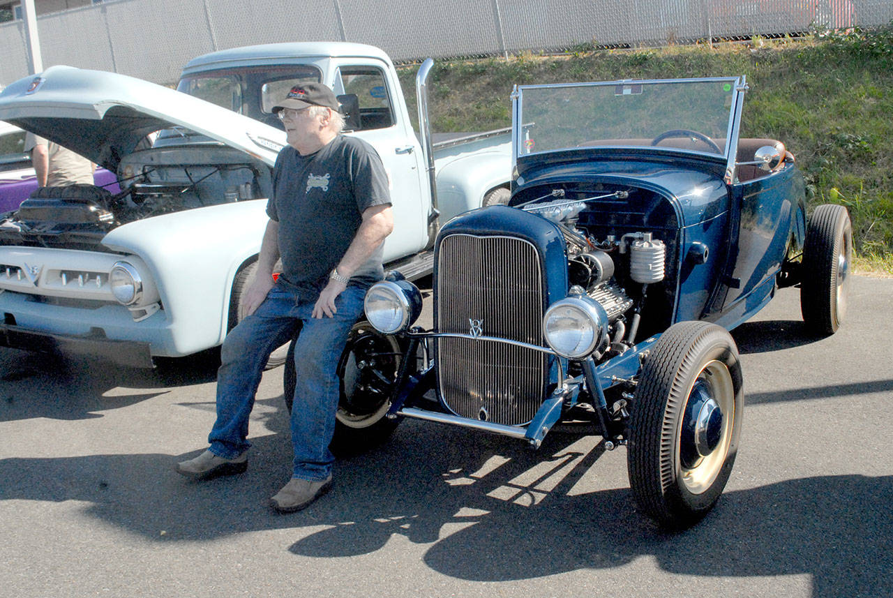 Bill Gainey of Sequim sits on the wheel of his 1928 Ford Roadster at Friday night’s Ruddell Cruise In in Port Angeles. (Keith Thorpe/Peninsula Daily News)