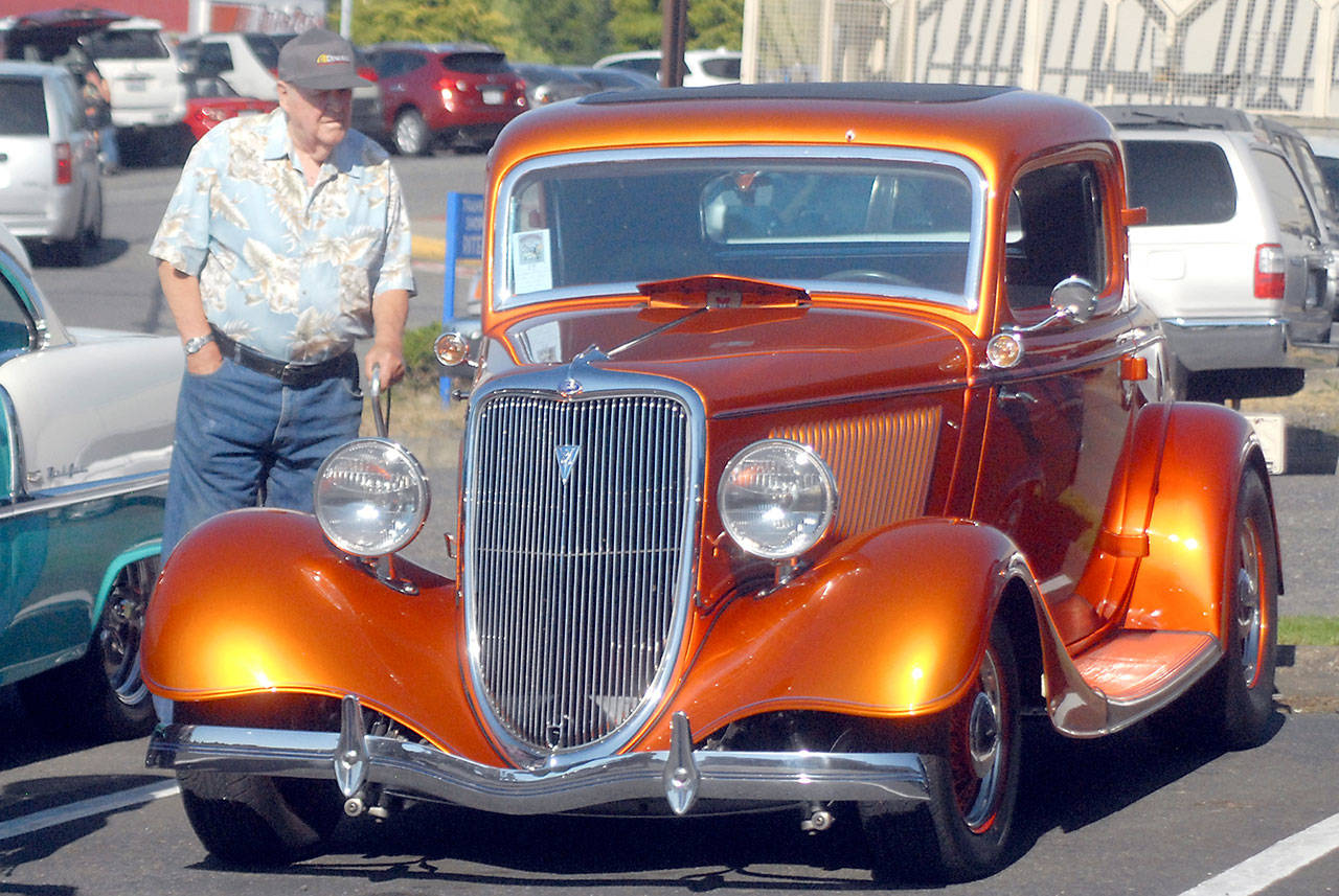 Terry Barlow of Port Angeles examines a 1934 Ford Coupe at the Ruddell Cruise In. (Keith Thorpe/Peninsula Daily News)