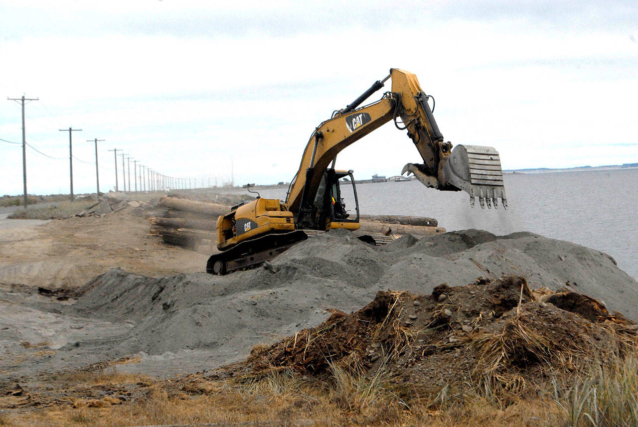 An excavator moves dirt and sand on Ediz Hook on Friday at the former site of the Olympic Peninsula Rowing Association’s boat house at the edge of Port Angeles Harbor. (Keith Thorpe/Peninsula Daily News)