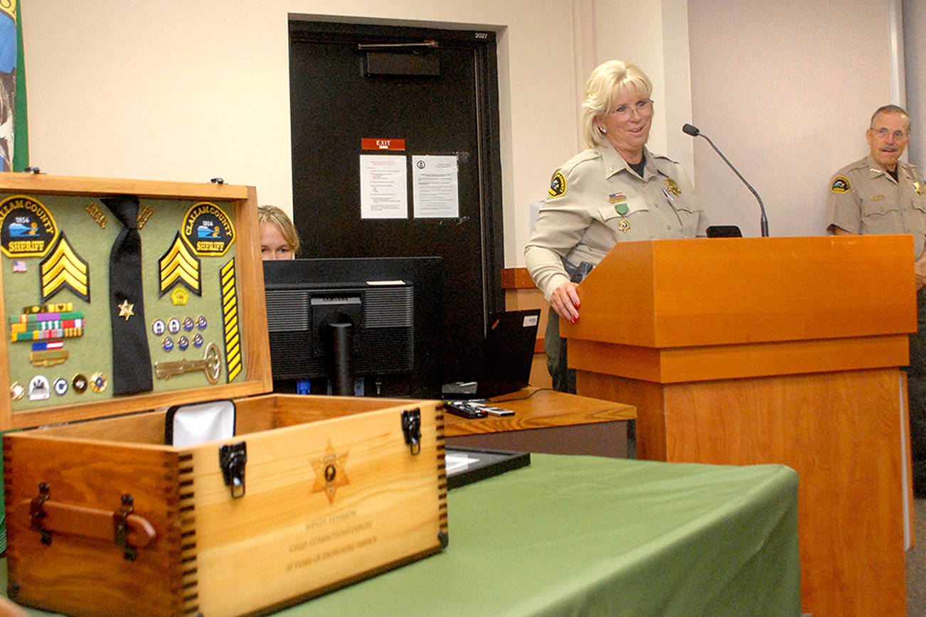 Keith Thorpe/Peninsula Daily News
Clallam County Chief Corrections Deputy Wendy Peterson, center, speaks at a retirement ceremony honoring her for 37 years of service with the Clallam County Sheriff's Office as Sheriff Bill Benedict watches at right. Peterson was recognized by county commissioners, friends and colleagues during Tuesday's commission meeting in Port Angeles in a ceremony that included a presentation of a chest full of memorabilia. Sheriff's Sgt. Don Wenzl will be promoted Aug. 2 to chief corrections deputy.