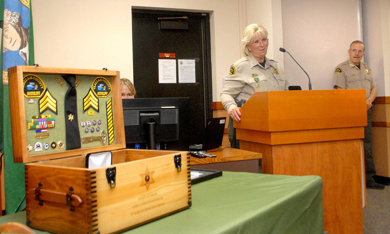 Clallam County Chief Corrections Deputy Wendy Peterson, center, speaks at a retirement ceremony honoring her for 37 years of service with the Clallam County Sheriffs Office as Sheriff Bill Benedict watches at right. (Keith Thorpe/Peninsula Daily News)