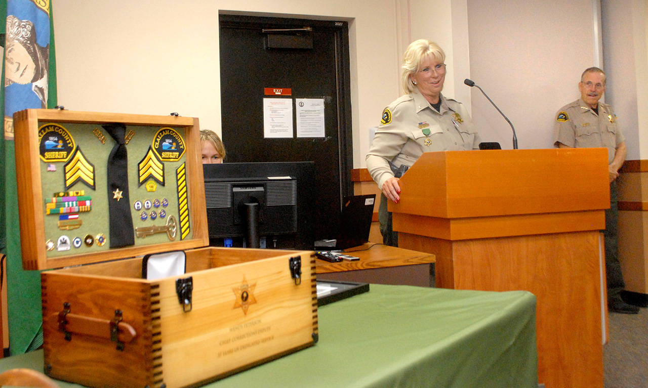 Clallam County Chief Corrections Deputy Wendy Peterson, center, speaks at a retirement ceremony honoring her for 37 years of service with the Clallam County Sheriff’s Office as Sheriff Bill Benedict watches at right. (Keith Thorpe/Peninsula Daily News)