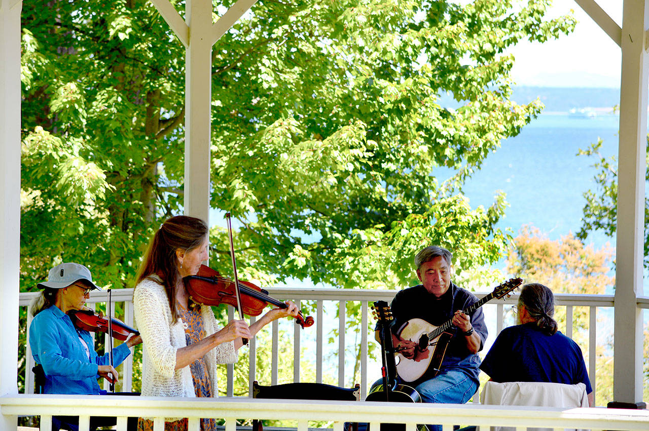 A group of friends from Jefferson and Island counties met Monday to play music as they do year-round at Port Townsend’s Chetzemoka Park gazebo. In the foreground is Dianne Boeger; playing Shetland Islands tunes with her, from left, are fiddler Mhaire Merryman, bouzouki and guitar player Donald Terao and English concertina player Len Feldman. (Diane Urbani de la Paz/Peninsula Daily News)