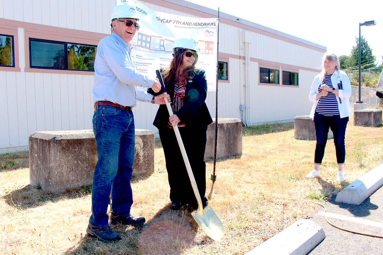 District 24 state legislature Rep. Steve Tharinger, left, and Cherish Cronmiller, Olympic Community Action Programs executive director, ceremoniously break ground for the newly dubbed “7th Haven” project during a celebration with about 100 attendees on Thursday afternoon at the site of the future housing facility. (Zach Jablonski/Peninsula Daily News)
