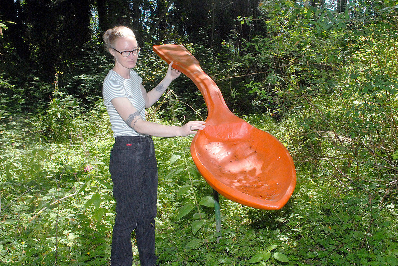 Sarah Jane, gallery and program director of the Port Angeles Fine Arts Center, admires Spoonful by Lucy Congdon Hanson, a featured art installation on Saturdays guided tour of Websters Woods Sculpture Park. (Keith Thorpe/Peninsula Daily News)
