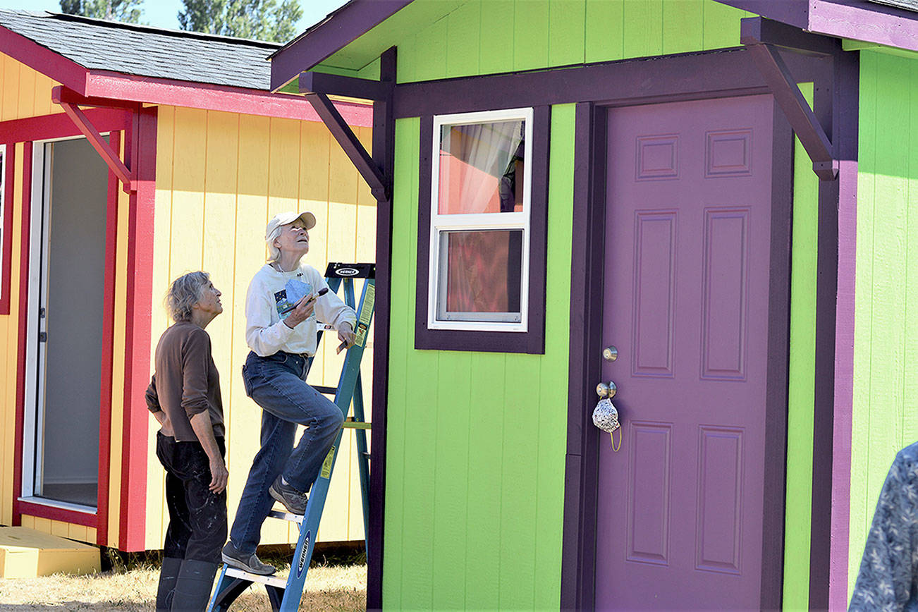 Cheryl Bentley, left, and Annalee McConnell are among the volunteers who’ve built, painted and furnished a village of tiny shelters off San Juan Avenue in Port Townsend. The Community Build site will host an open house Saturday afternoon. (Diane Urbani de la Paz/Peninsula Daily News)