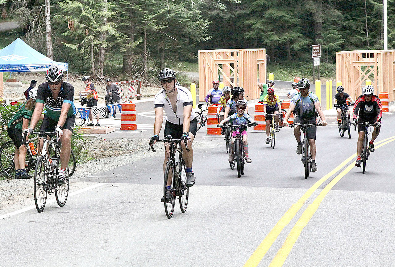A group of Ride the Hurricane riders pass the new entrance station being built on Hurricane Hill Road. Elinor Jones, 9, from Sequim, was one of the youngest riders in the event that climbs 17 miles and 5,242 feet of elevation to the top of Hurricane Ridge. (Dave Logan/for Peninsula Daily News)