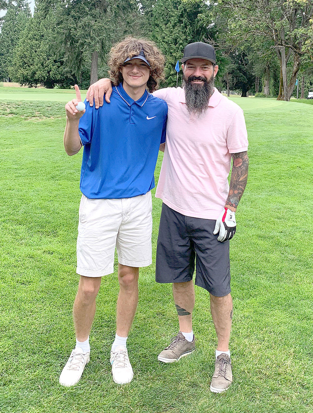 Port Angeles’ Edun Bailey, left, celebrates his hole in one with his father Matt Bailey during the Bellevue Amateur tournament this weekend at the Bellevue Golf Course. (Photo courtesy of Matt Bailey)