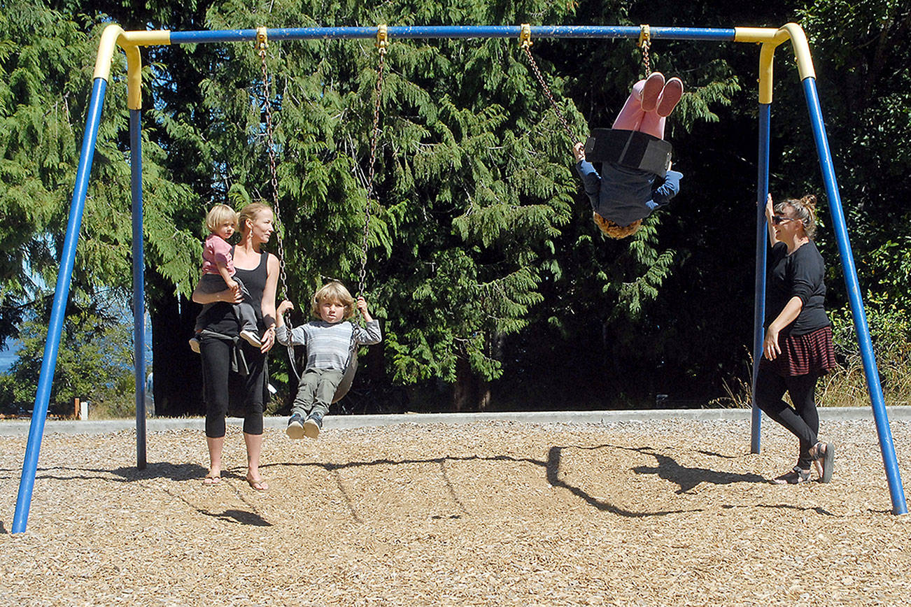 Sooni Gillett of Santa Cruz, Calif., left, along with her sons, Cody Strong-Cvetich, 2, and Jack Strong-Cvetich, 4, talks with Emily Gherard of Seattle, right, as her daughter, Etta Swope, 5, swings high on the playground equipment at Salt Creek Recreation Area north of Joyce on Wednesday. The Clallam County-operated park is a popular outdoors destination for visitors to the North Olympic Peninsula. (Keith Thorpe/Peninsula Daily News)