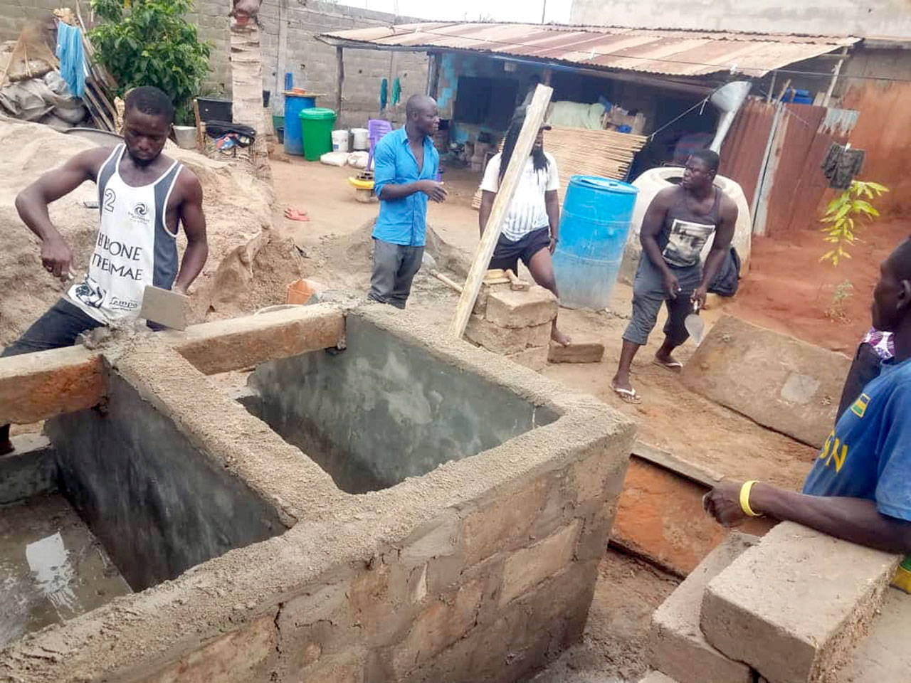 Workers build a composting toilet for a family in Togo.