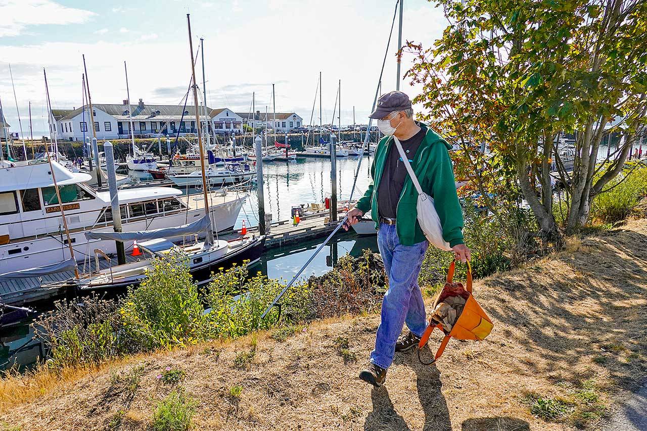 Gary Engbrecht has a hobby like no other. “Everyone needs a hobby,” he says. “Mine is picking up trash strewn around the town. I think I’ve emptied this bag about five times already and it is just 9 a.m.” During the weekend, Engbrecht, who is the production manager for the Port Townsend Film Festival, concentrated his efforts at the Point Hudson Marina in Port Townsend. (Steve Mullensky/for Peninsula Daily News)