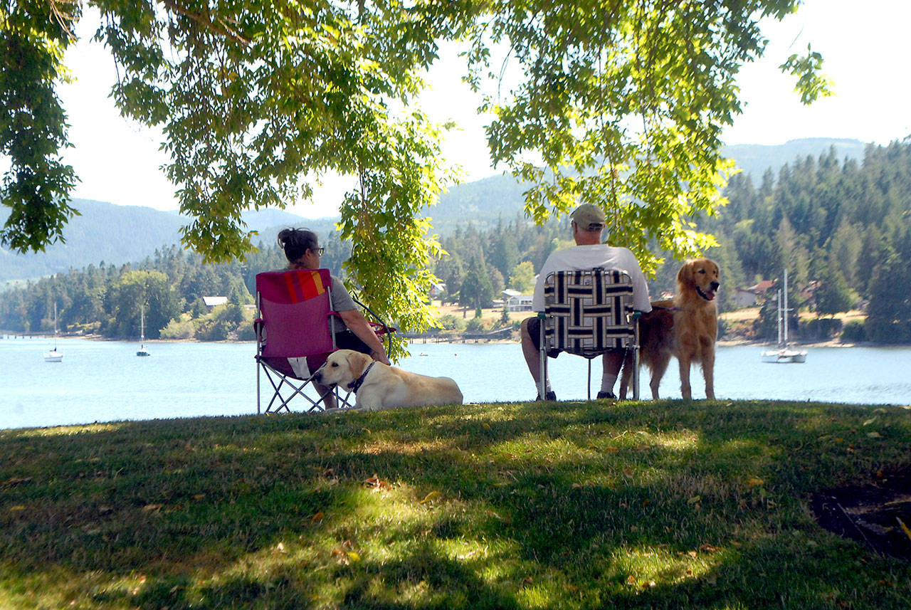 Laurie and Ford Rathbun of Bonney Lake, along with dogs Chevy and Jack, take in the view of Sequim Bay from John Wayne Marina near Sequim. The couple and their pets were staying in a nearby RV park and decided to spend part of their day lounging by the bay. (Keith Thorpe/Peninsula Daily News)