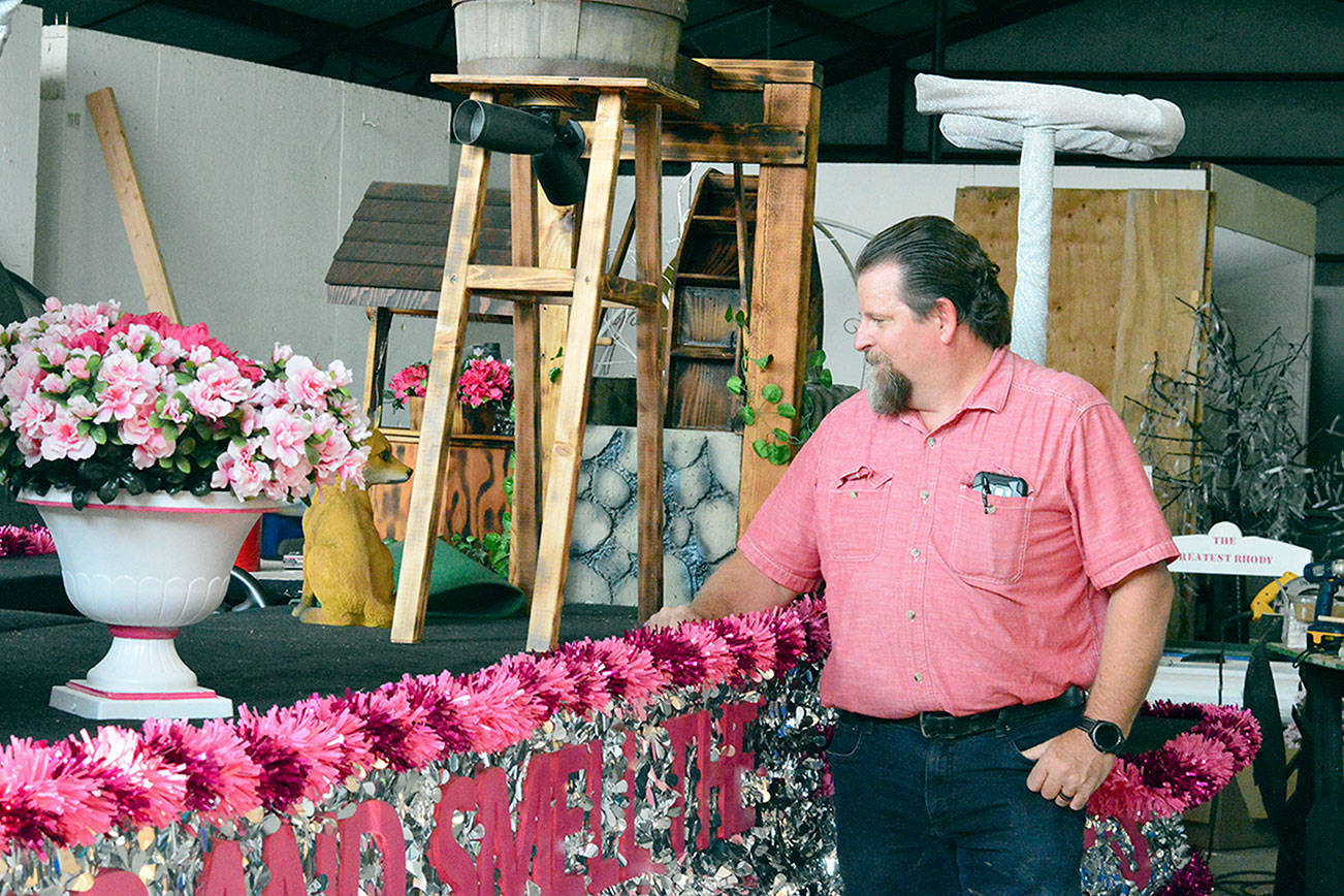 Builder Bliss Morris is preparing the "Stop and Smell the Rhodies"-themed float for Saturday's Rhody Grand Parade. (Diane Urbani de la Paz/Peninsula Daily News)