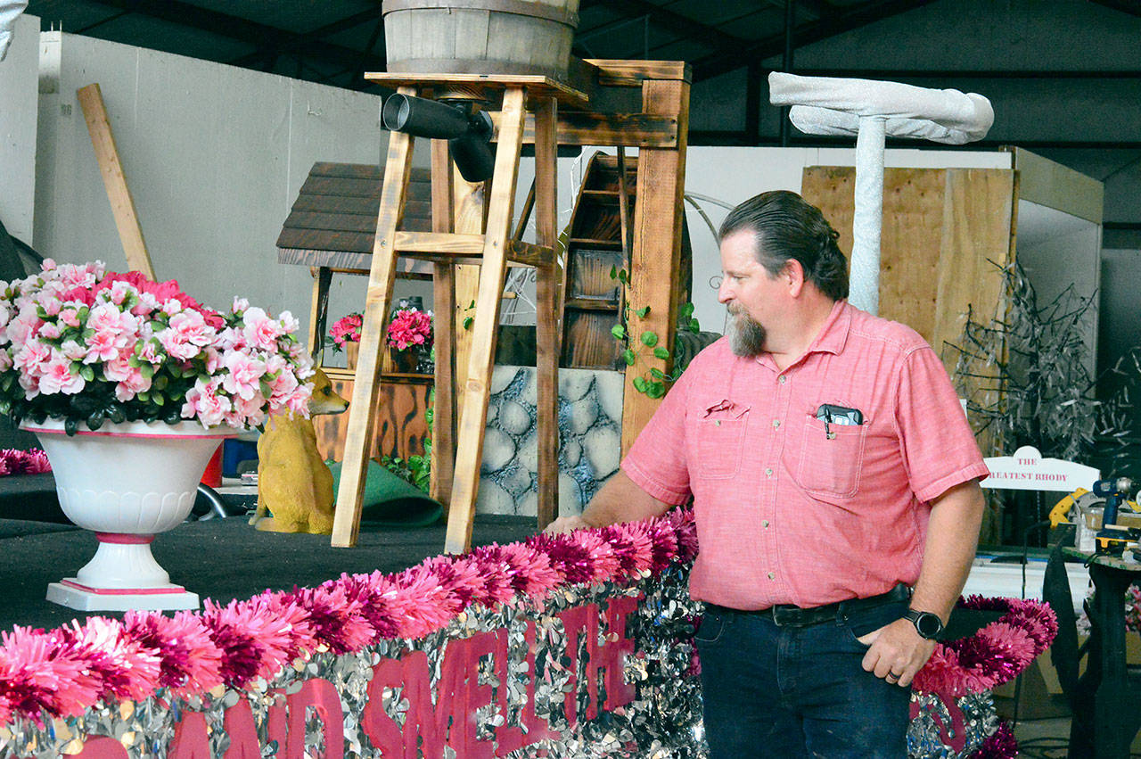 Builder Bliss Morris is preparing the “Stop and Smell the Rhodies”-themed float for Saturday’s Rhody Grand Parade. (Diane Urbani de la Paz/Peninsula Daily News)