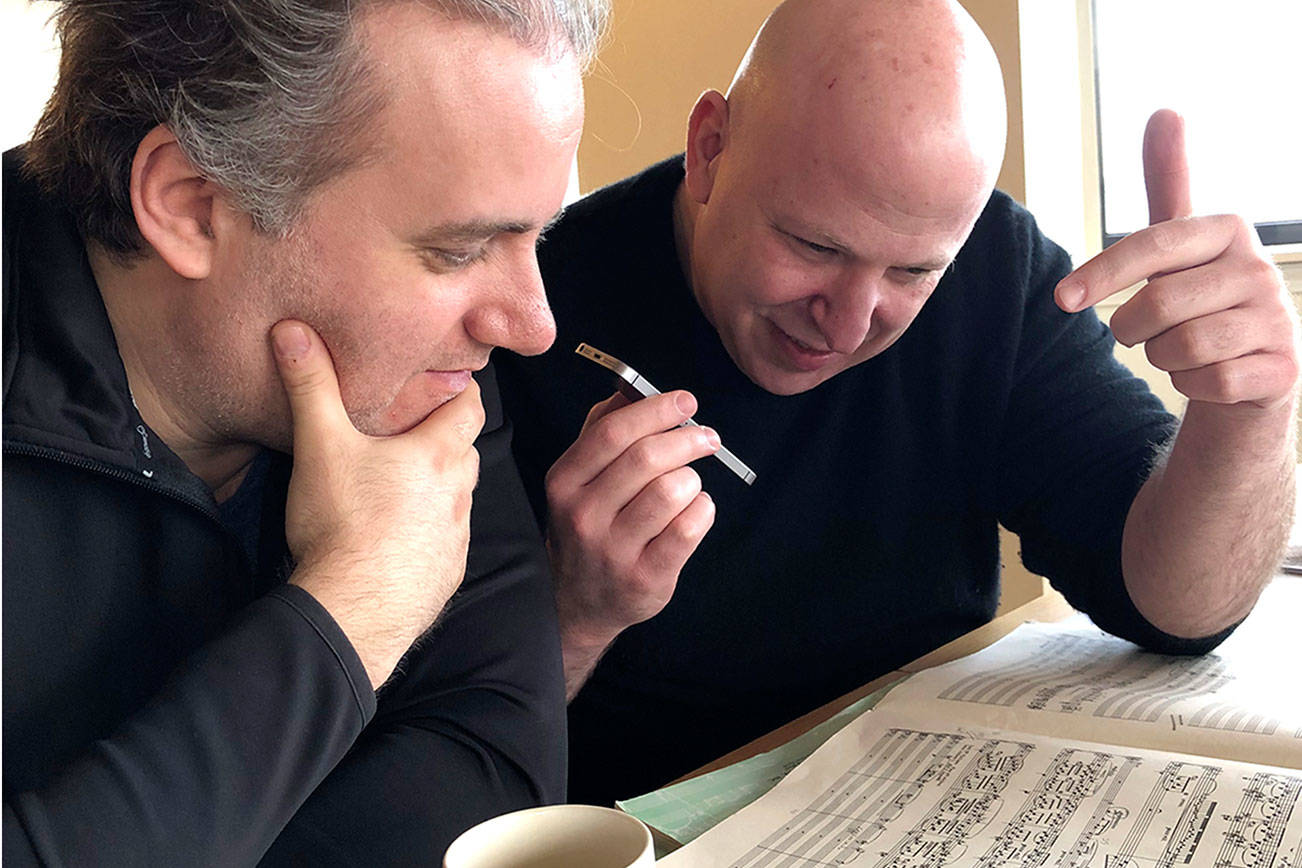 Pianist Josu de Solaun, left, and Port Angeles Symphony conductor Jonathan Pasternack, pictured in Port Angeles in February 2020, pore over the music they will record this month in the Czech Republic. (Photo by Dorthe Grube Porter/Port Angeles Symphony)