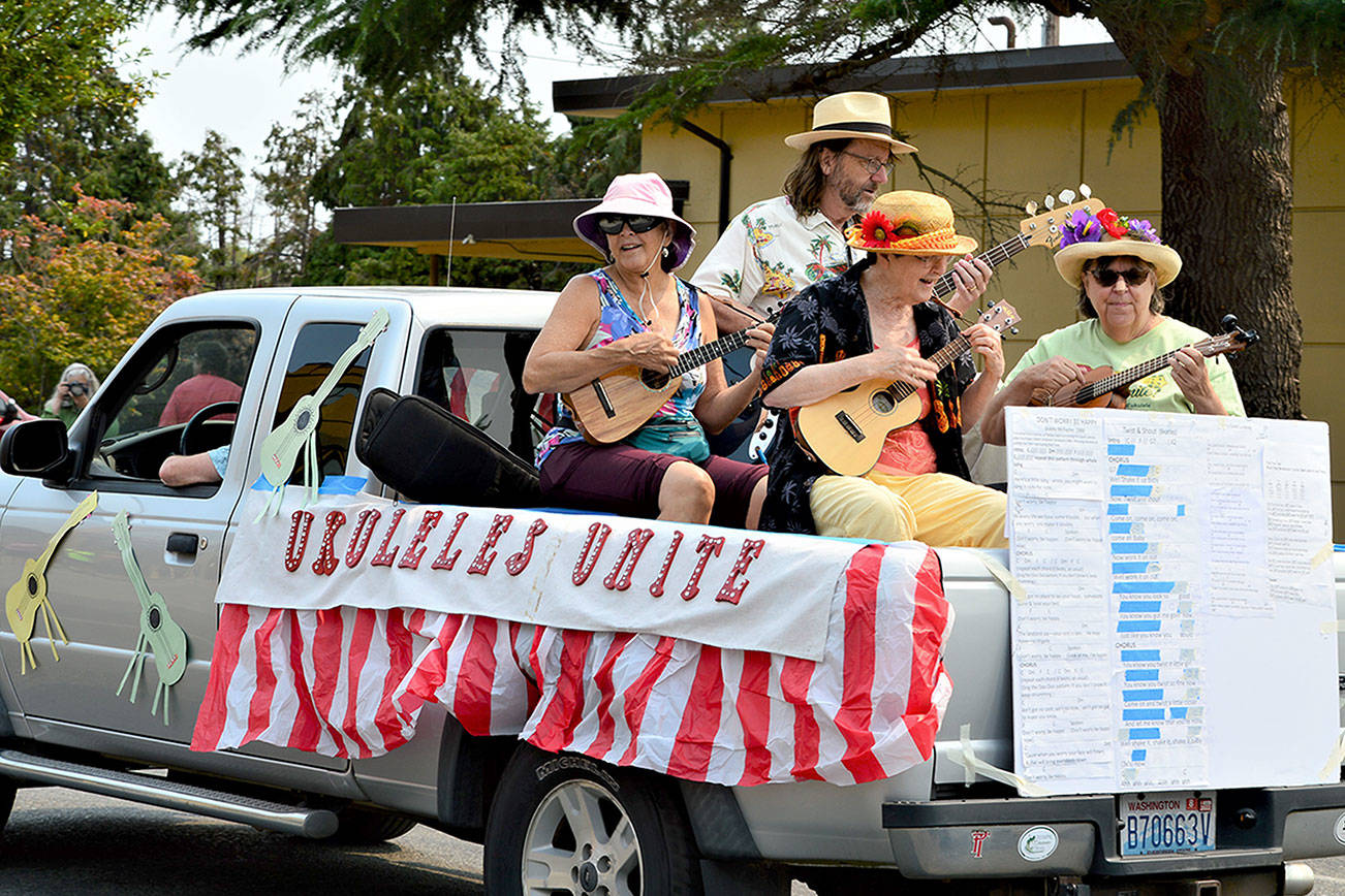 Ukuleles Unite! group strummed and sang its way down Lawrence Street in Saturday's Rhododendron Festival Grand Parade. The procession gathered 40 entries and hundreds of spectators to Uptown and downtown Port Townsend.   (Diane Urbani de la Paz/Peninsula Daily News)