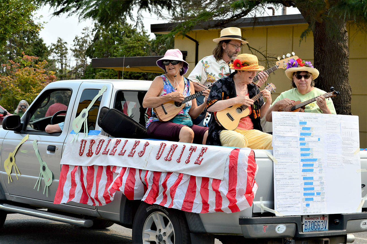 Ukuleles Unite! group strummed and sang its way down Lawrence Street in Saturday’s Rhododendron Festival Grand Parade. The procession gathered 40 entries and hundreds of spectators to Uptown and downtown Port Townsend. (Diane Urbani de la Paz/Peninsula Daily News)
