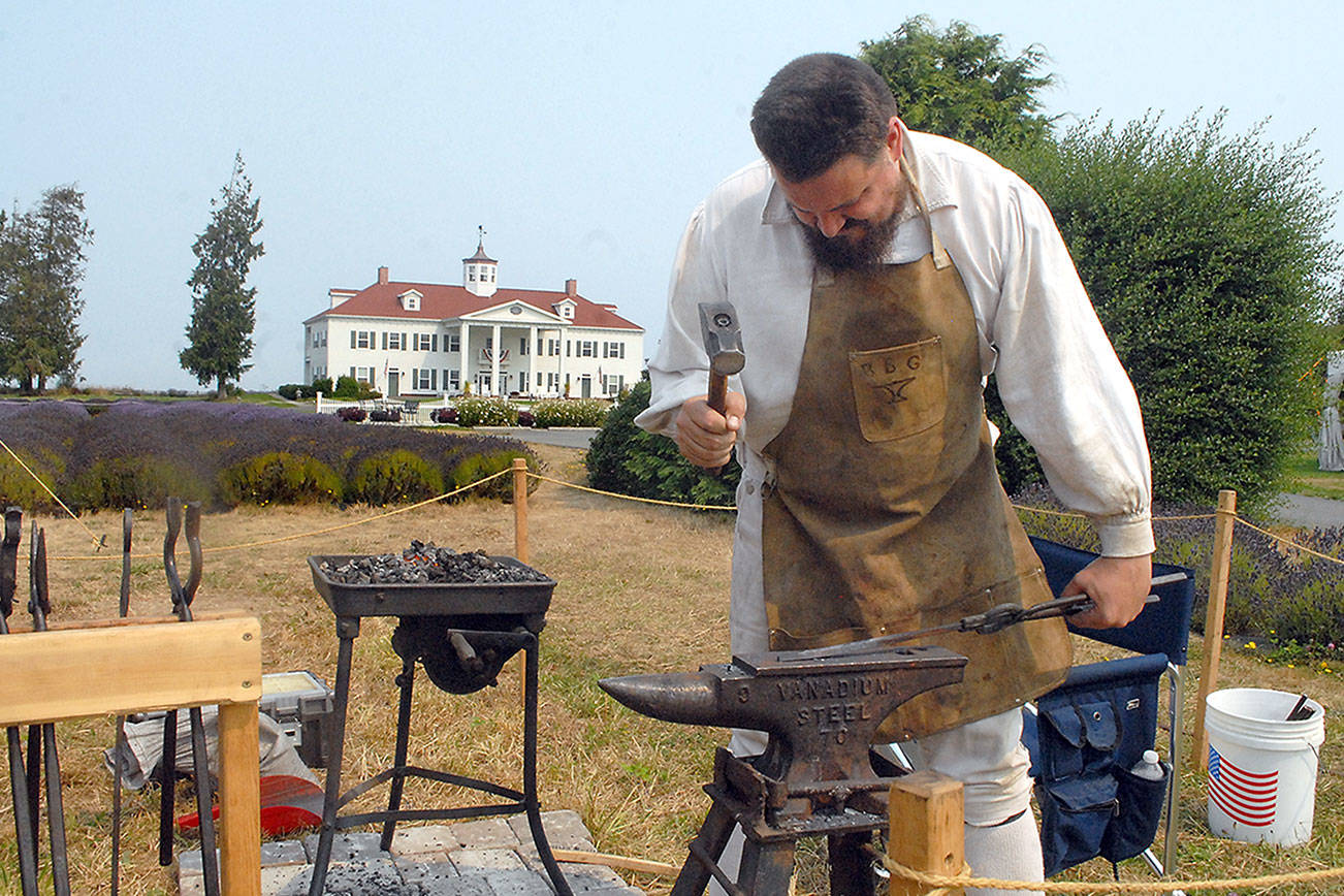 Blacksmith Keith Chester of Arlington pounds hot metal during a smithing demonstration on Saturday at Northwest Colonial Festival on the grounds of the George Washington Inn and Estate east of Port Angeles. The event featured displays, demonstrations and reenactments of life during the colonial era of the American Revolution. (Keith Thorpe/Peninsula Daily News)