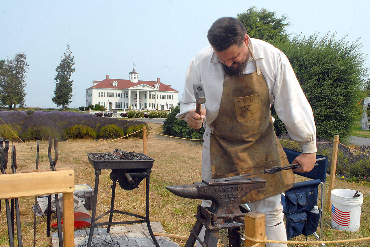 Blacksmith Keith Chester of Arlington pounds hot metal during a smithing demonstration on Saturday at Northwest Colonial Festival on the grounds of the George Washington Inn and Estate east of Port Angeles. The event featured displays, demonstrations and reenactments of life during the colonial era of the American Revolution. (Keith Thorpe/Peninsula Daily News)