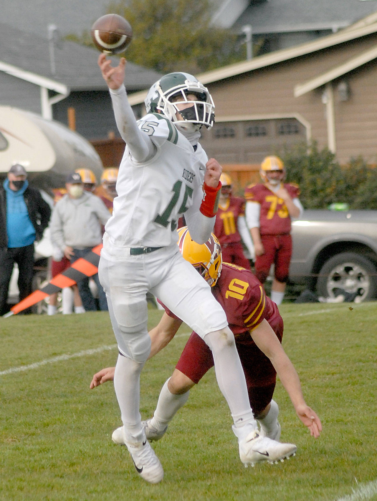 Port Angeles quarterback Parker Nickerson gets off a pass as Kingston’s Kyler Coe-yarr closes in during a Roughriders win earlier this year. (Keith Thorpe/Peninsula Daily News)