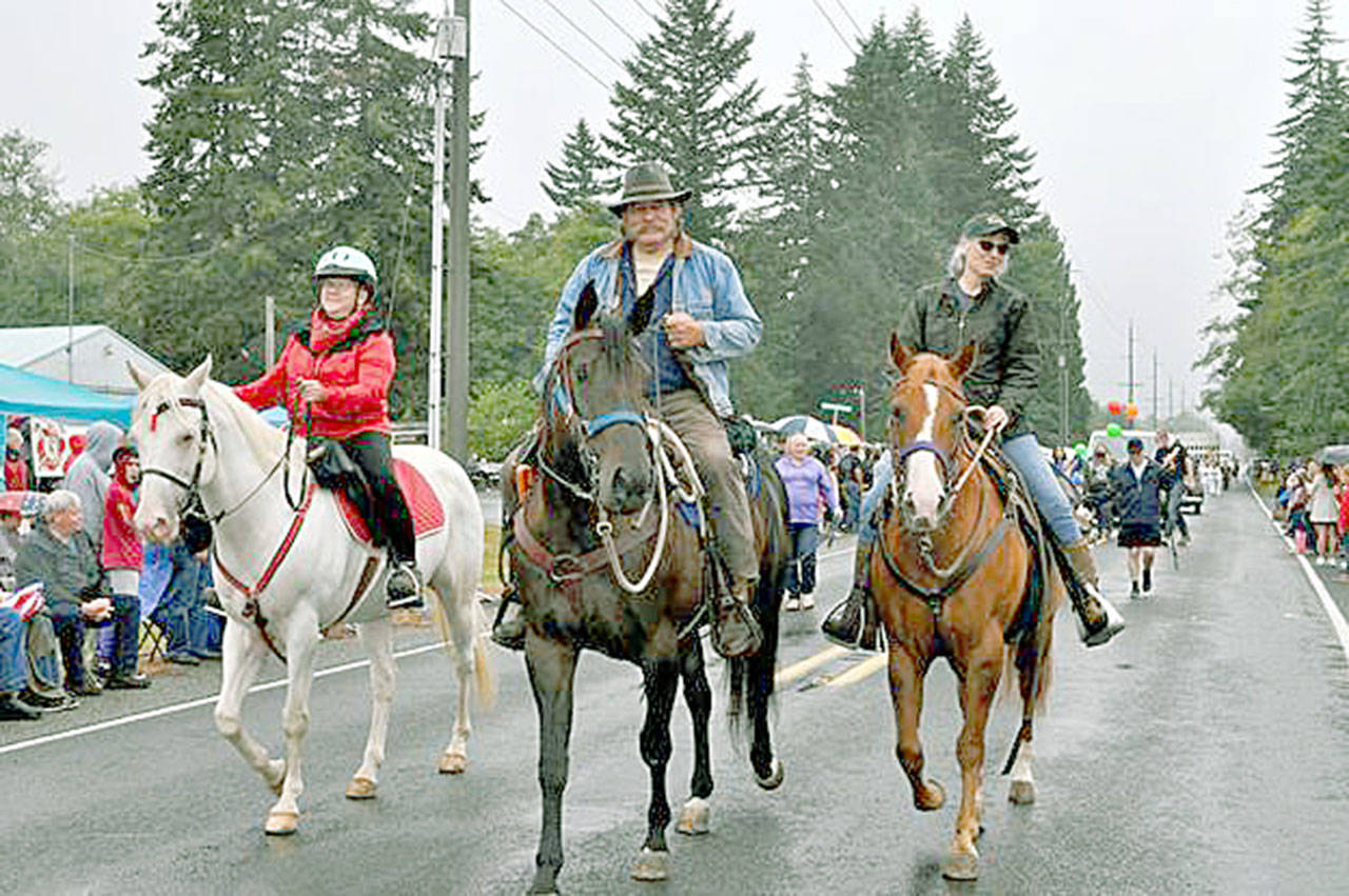Back Country Horsemen of Washington members Linda Morin, left, Ray and Rochelle Sutherland had a grand time leading the equine entries in the parade as a part of the Joyce Daze Wild Blackberry Festival. Members from three Olympic Peninsula chapters participated. (Photo by Denise Hupfer/Peninsula chapter Back Country Horsemen of Washington)