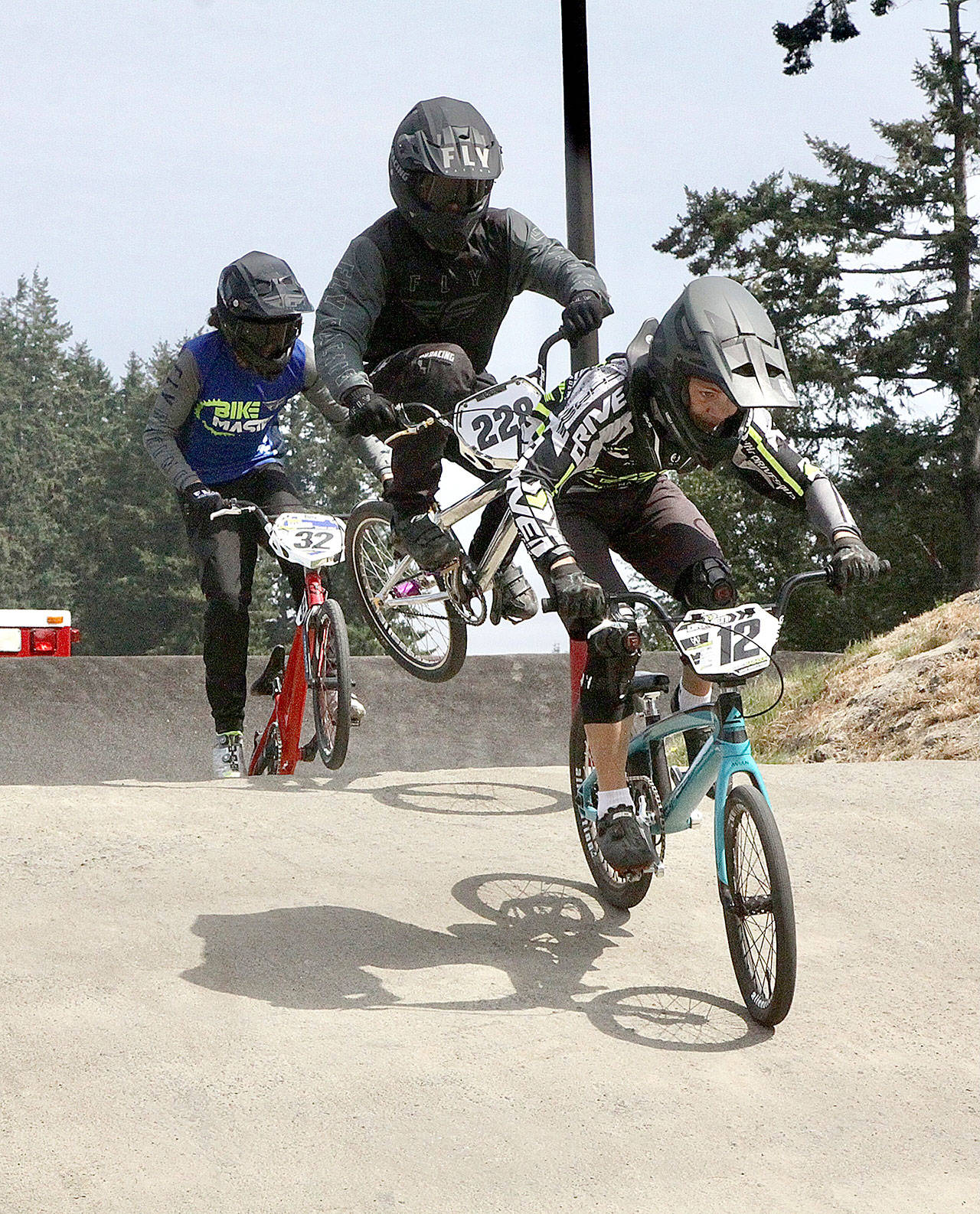 Dave Logan/for Peninsula Daily News No. 32 Damien Avila of Spokane and No. 228 Vaunn Zimmerman of Redmond doing a little wiggle with his bike trying to get some advantage to overtake the leader and in the lead No. 12 Peyton Calhoun of Port Orchard in Sunday’s Gold Cup qualifier at the Lincoln Park BMX track in Port Angeles.