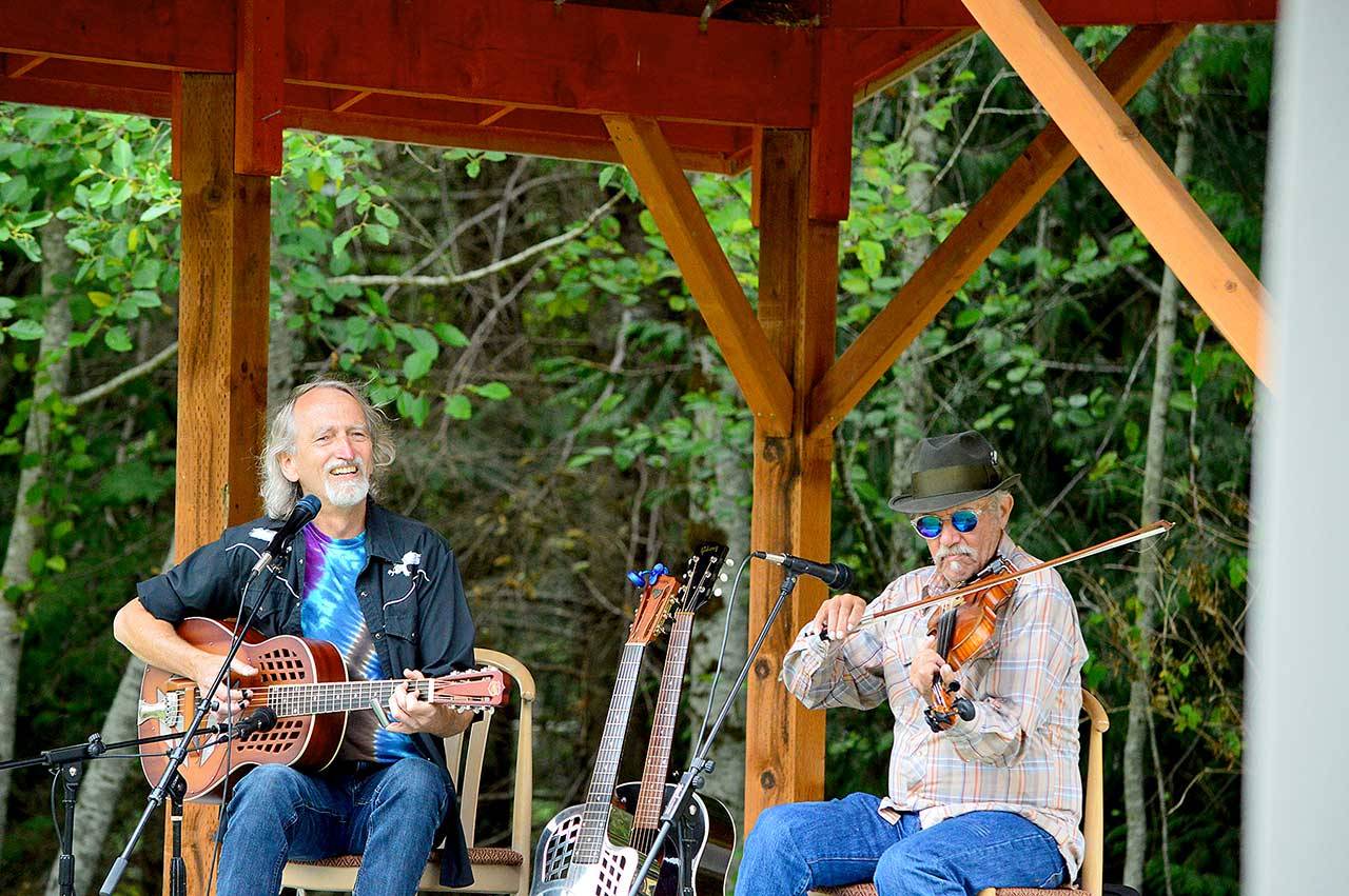 John “Greyhound” Maxwell, left, and Jon Parry dish up blues and swing Saturday afternoon outside the Laurel B. Johnson Community Center in Coyle. Their show was likely to be the last of the season’s Concerts in the Woods series. (Diane Urbani de la Paz/Peninsula Daily News)