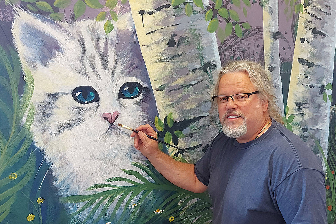 Port Angeles artist Dave Montague works on a mural at the Olympic Peninsula Humane Society’s McKay Kitty City near Sequim. (Photo courtesy of Olympic Peninsula Humane Society)