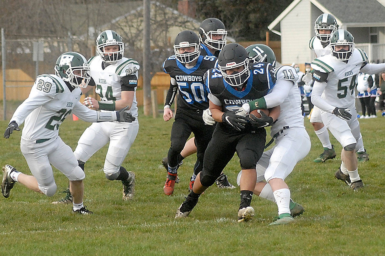 East Jefferson ball carrier Anson Jones, center, is wrapped up by Port Angeles' Jacob Felton as he breaks through the line during a February 2021 contest. Jones is expected to start at fullback once again for the newly christened 'Rivals.' (Keith Thorpe/Peninsula Daily News)