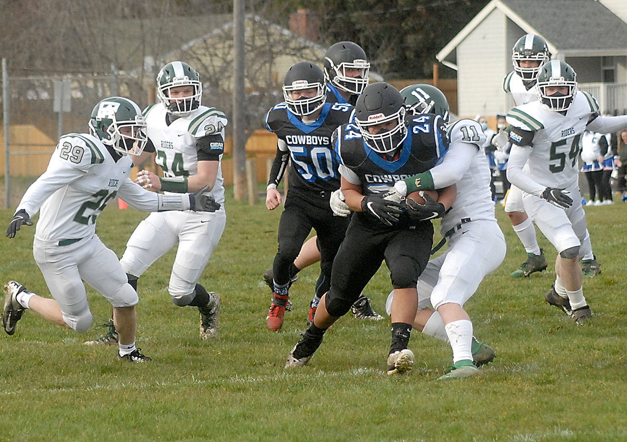 East Jefferson ball carrier Anson Jones, center, is wrapped up by Port Angeles’ Jacob Felton as he breaks through the line during a contest in February. Jones is expected to start at fullback once again for the newly christened Rivals. (Keith Thorpe/Peninsula Daily News)