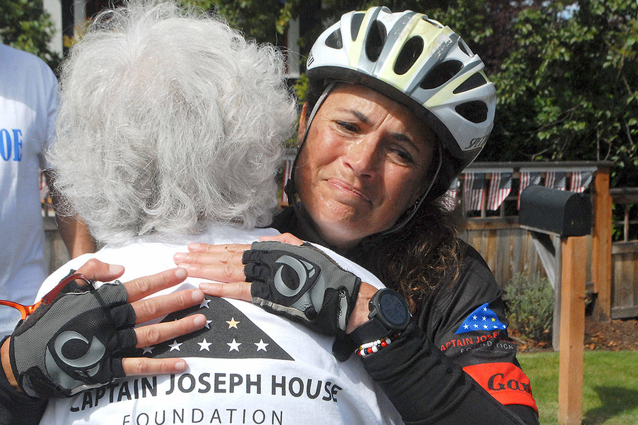 Keith Thorpe/Peninsula Daily News
Special education kindergarten teacher Amy DelaBarre of Port Angeles gives an emotional hug to Betsy Schulz, founder of the Captain Joseph House Foundation in Port Angeles, after DelaBarre completed the bicycle portion of "Run for Joe," a solo triathelion on Saturday to raise funds in support of Gold Star families who have lost loved ones in military action. The Captain Joseph House, a former bed-and-breakfast which was converted to give respite to military families, is named for Schultz' son, Joseph Schultz, who was killed in action in Afghanistan on May 29, 2011.