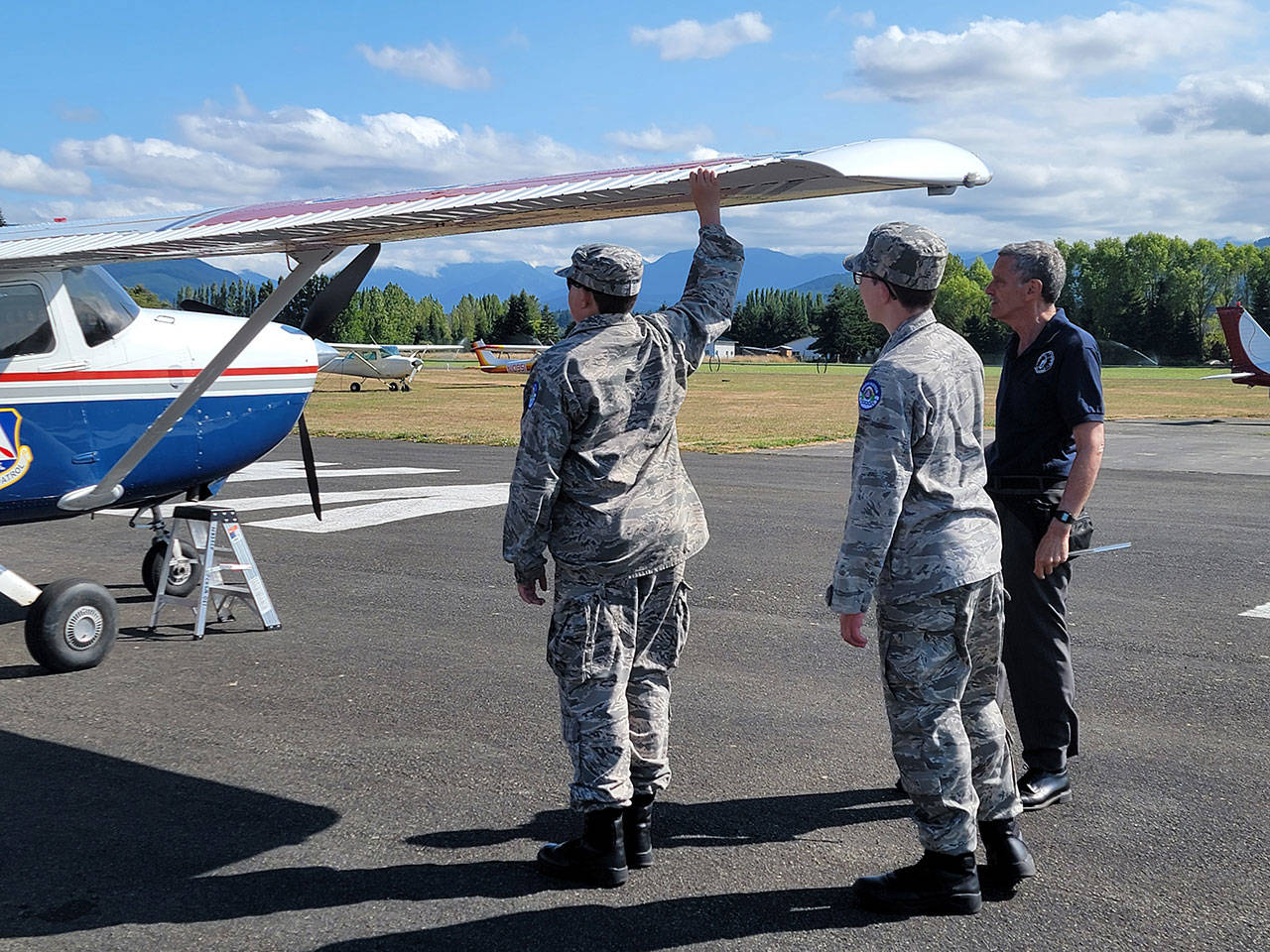 Cadets Joseph Maggard of Port Angeles and Reilly Sue of Sequim test aircraft aileron as Capt. John Weidman of Bremerton looks on.