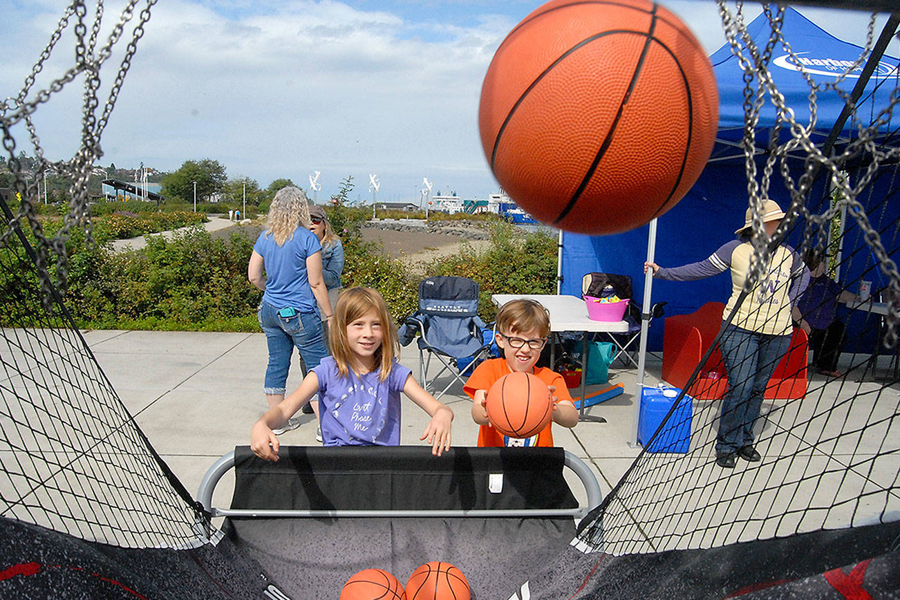 Cousins Ivy Bishop, 7, of Bellingham, left, and Maeve Caron, 6, or Portland, Ore., toss basketballs during a hoops game set up at Pebble Beach Park in Port Angeles during the 2019 Jammin' in the Park. (Keith Thorpe/Peninsula Daily News)