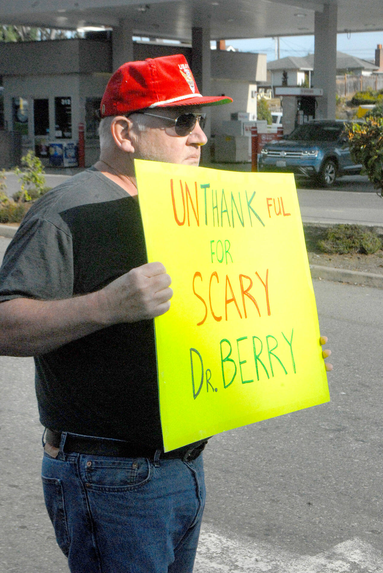 Jerry Ludke tiene un cartello che avverte la dottoressa Allison Berry, funzionario sanitario della contea di Clam e Jefferson, durante una manifestazione contro i mandati di vaccino venerdì.  (Keith Thorpe/The Peninsula Daily News)