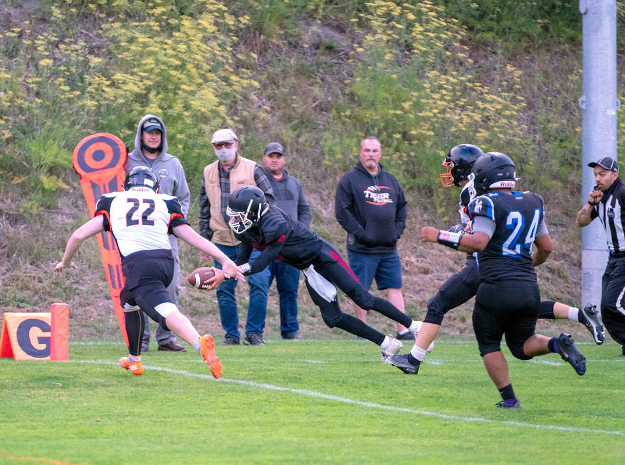 Steve Mullensky/for Peninsula Daily News Granite Falls Tiger, Connor Wichman, (11) can only watch as East Jefferson Rival, Cash Holmes, dives into the end zone for six points after a 10 yard dash from scrimmage during a Friday night game in Port Townsends Memorial Field.
