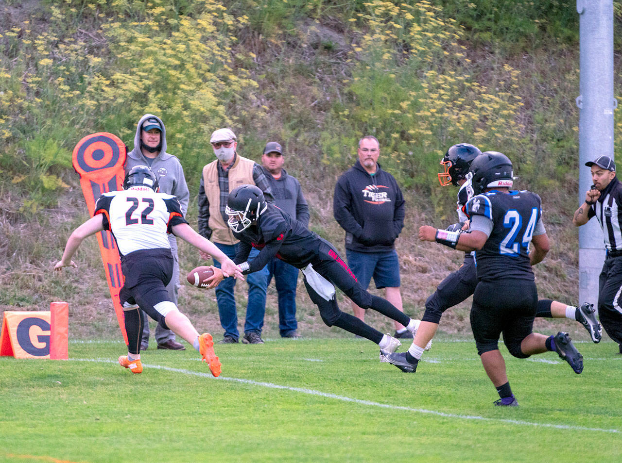 Steve Mullensky/for Peninsula Daily News Granite Falls Tiger, Connor Wichman, (11) can only watch as East Jefferson Rival, Cash Holmes, dives into the end zone for six points after a 10 yard dash from scrimmage during a Friday night game in Port Townsend’s Memorial Field.