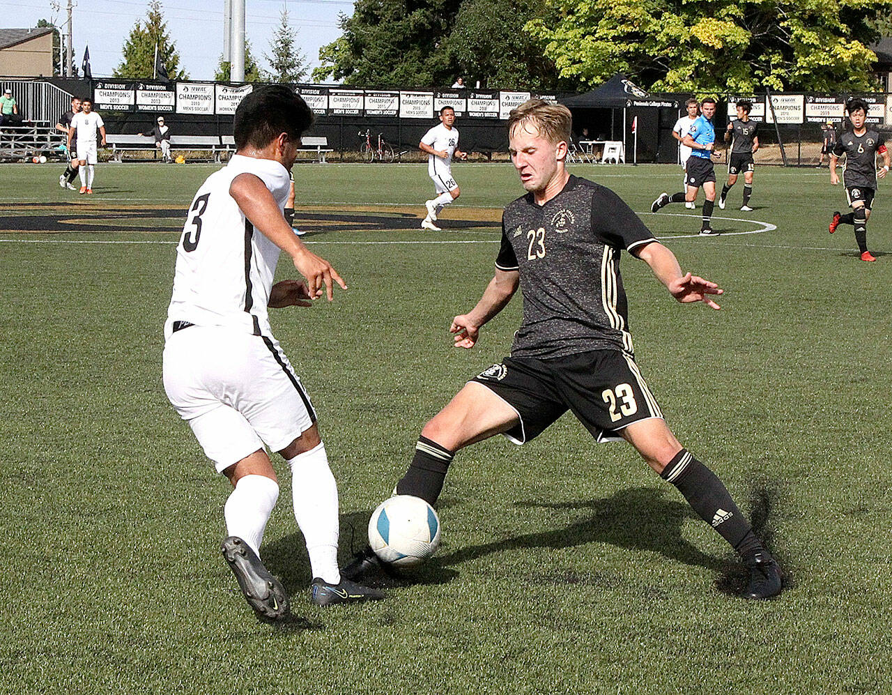 Peninsula College’s Tim Deser (23) fights for the ball with Wenatchee Valley’s Sebastian Aviles on Sunday afternoon at Wally Sigmar Field. The Pirates won 3-0 behind three goals in the second half. (Dave Logan/for Peninsula Daily News)