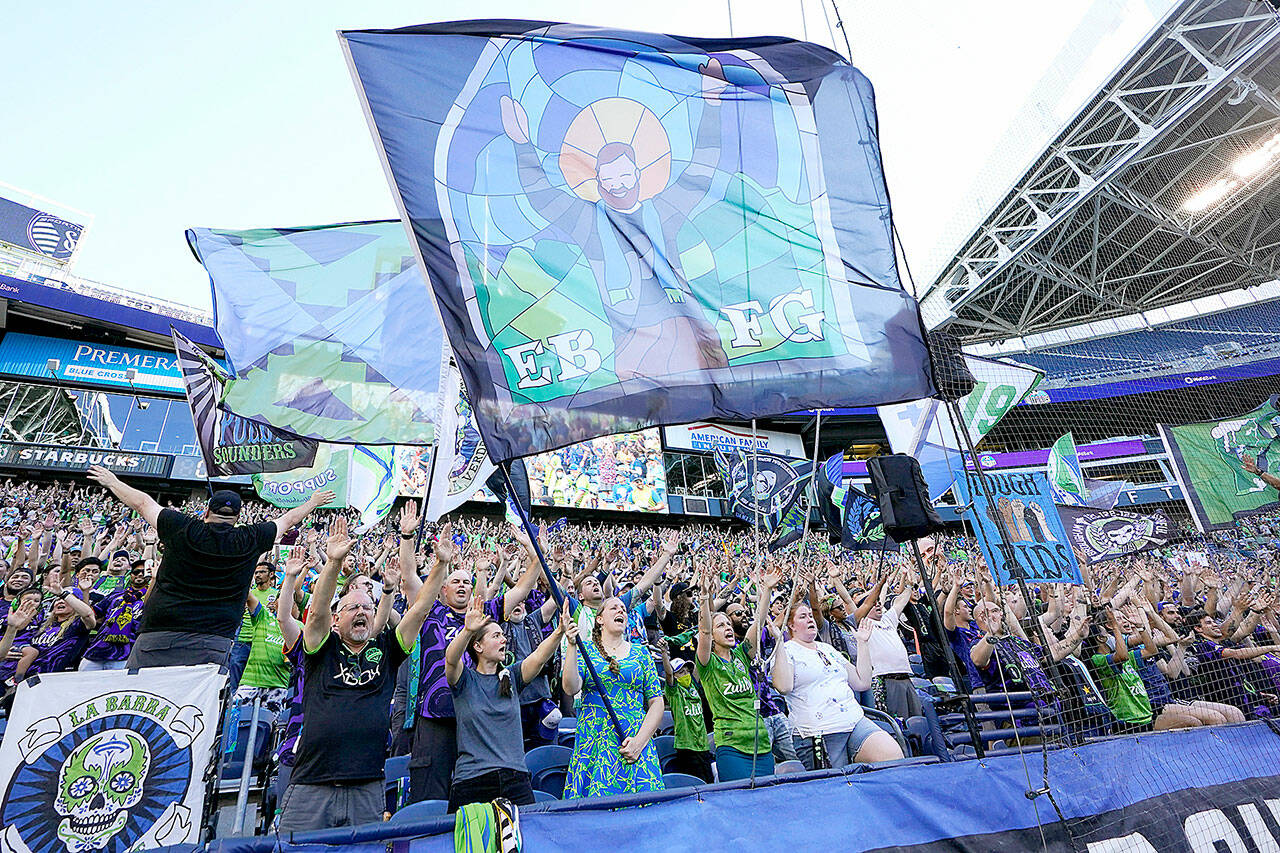 FILE - In this July 25, 2021, file photo, members of the Emerald City Supporters and other fans wave flags and cheer before an MLS soccer match between the Seattle Sounders and Sporting Kansas City in Seattle. Fans attending most pro sporting events in Seattle will soon be required to show proof theyve been vaccinated against COVID-19 or that theyve tested negative for the virus. The NFLs Seahawks, MLSs Sounders, NHLs Kraken and the University of Washington all announced updated policies Tuesday, Sept. 7, 2021, for fans attending games this season. (AP Photo/Ted S. Warren, File)