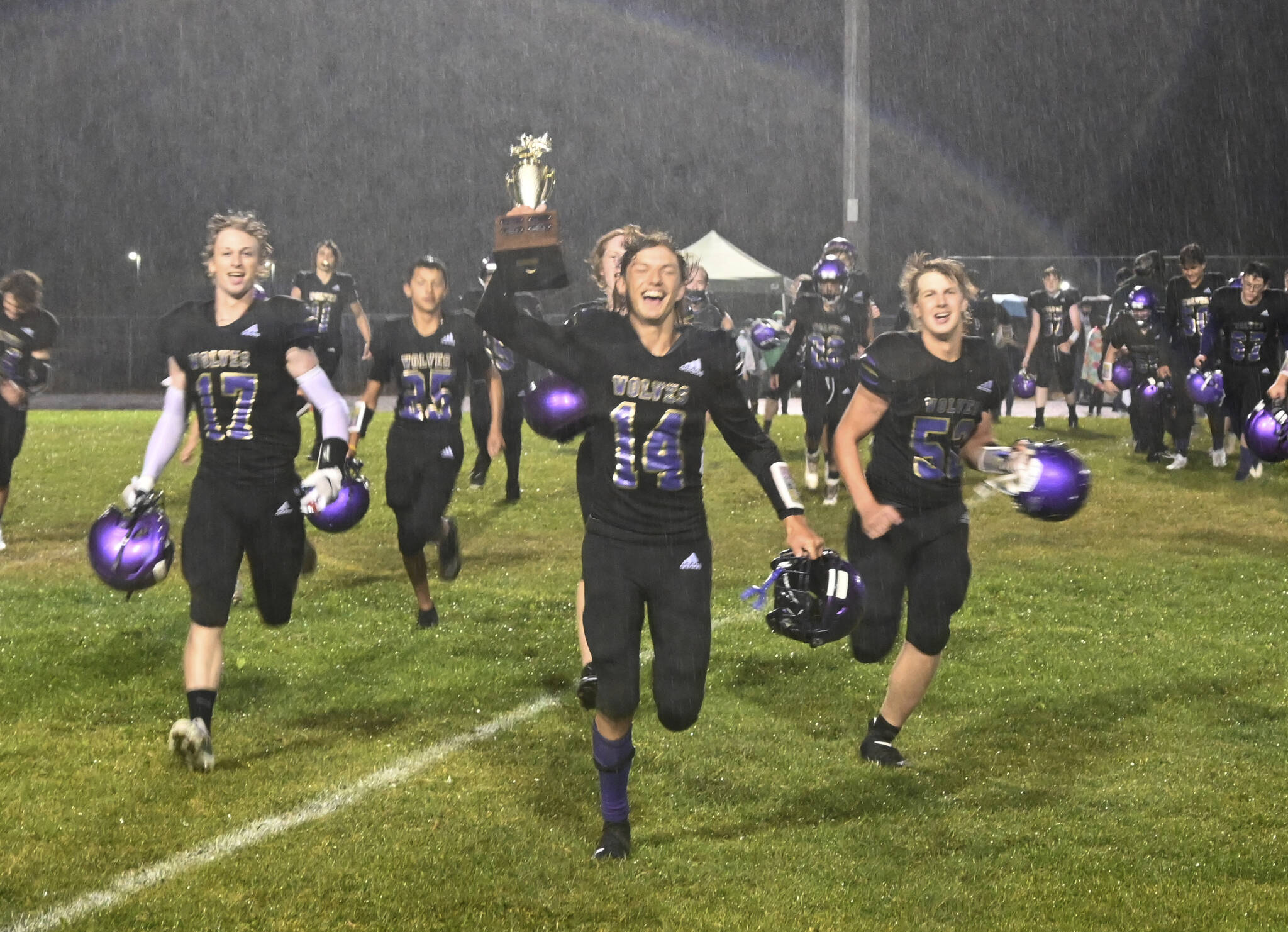 Michael Dashiell/Olympic Peninsula News Group
Sequim's Kobe Applegate holds the Rainshadow Rumble rivalry trophy as the team heads toward the student section to sing the school fight song after a 17-12 win over Port Angeles on Friday.