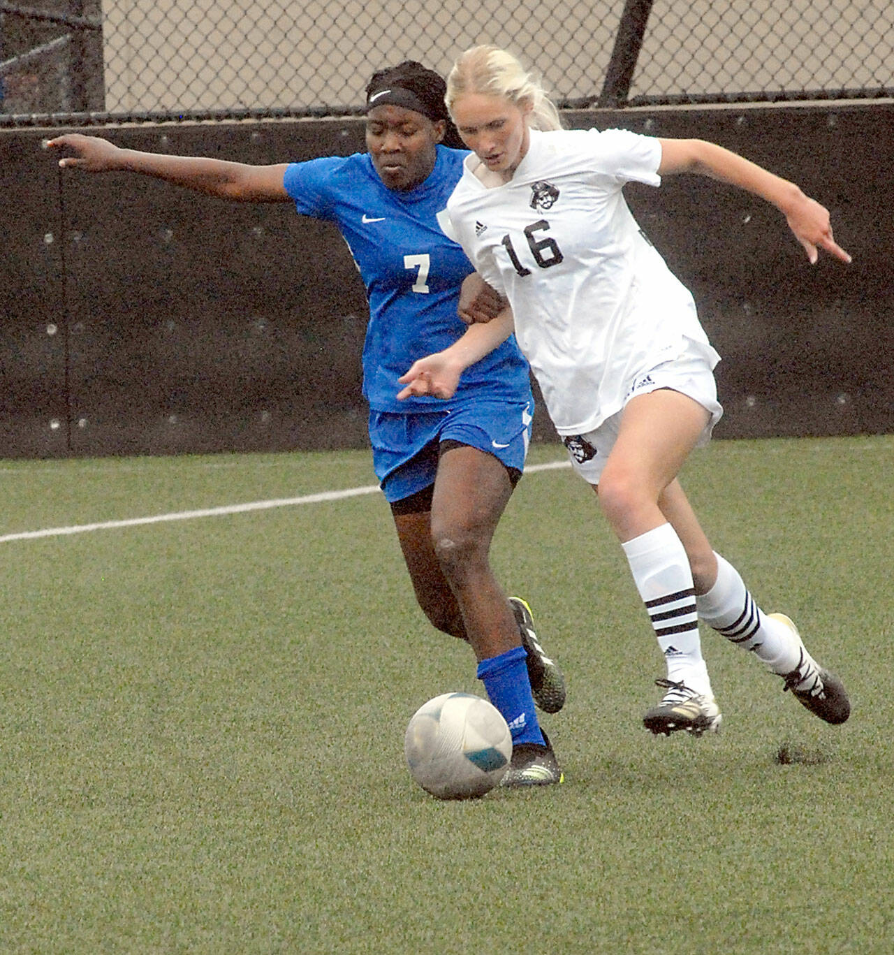 Peninsulas Millie Long, a graduate of Port Angeles High School, right, tries to outrace Edmonds Flero Dina Surpris on Wednesday at Wally Sigmar Field in Port Angeles. (Keith Thorpe/Peninsula Daily News)