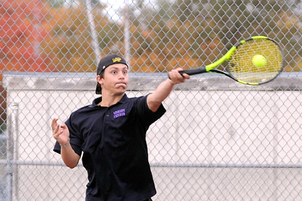 Sequim’s Espn Judd rips a forehand volley as he and teammate Kaiden Jones take on Olympic’s Warner Alexander and Freddy Enamorato on Wednesday in Sequim. Jones and Judd won, 6-2, 6-1, as the Wolves swept the Trojans 7-0. (Michael Dashiell/Olympic Peninsula News Group)